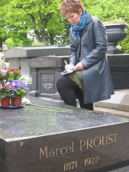 Patti Miller écrivant dans un carnet à côté de la tombe de Marcel Proust