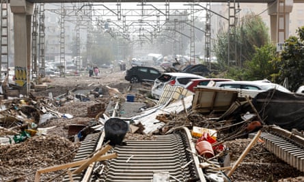 Damaged cars lie amid debris along damaged rail lines in the flood-hit city of Valencia.
