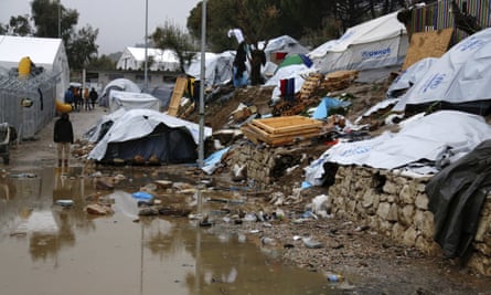 A refugee stands next to a pool of mud at Moria refugee camp in Lesbos