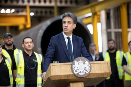 Ed Miliband, the energy secretary, gives a speech surrounded by men in hi-vis jackets at a factory