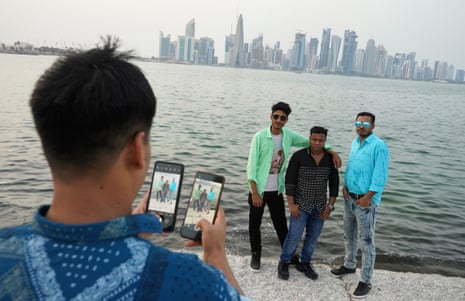Bangladeshis pose on the Corniche in Doha on a public holiday with the city’s skyscrapers and skyline in the background.