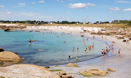 Sunbathers and swimmers at a Brittany beach.