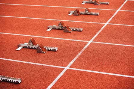 Five empty starting blocks on a running track, going diagonally across the image