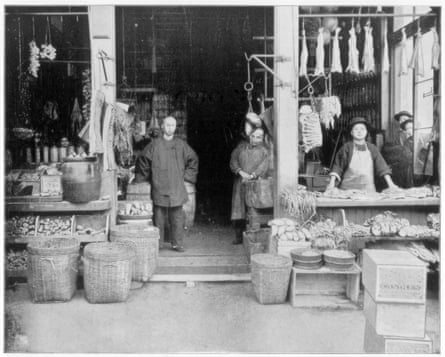 men in traditional Chinese garb outside a shop