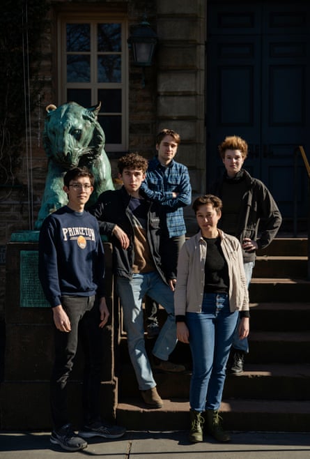 Group of five students standing for a portrait in front of an old university building