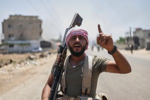 A Bedouin fighter with a rifle points to the sky