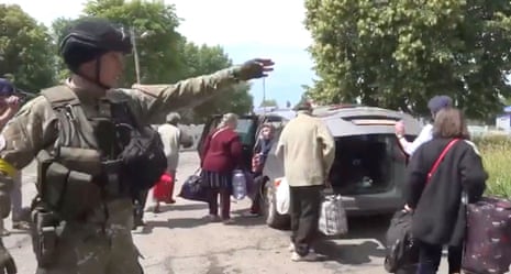 A still from a video showing a police officer evacuating people at a location given as Pryvillia town, Luhansk.