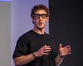 Mark Zuckerberg, wearing Meta glasses, gestures while speaking on stage