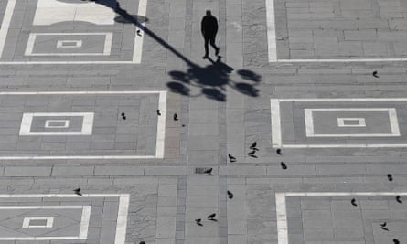 A man walks across the normally crowded Duomo square in central Milan on Sunday
