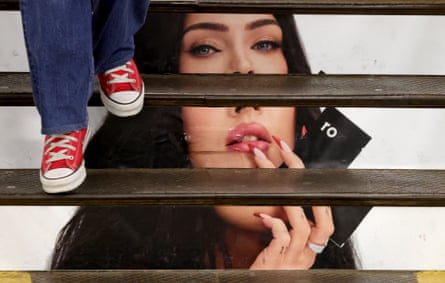 A person walks past an ad of Megan Fox