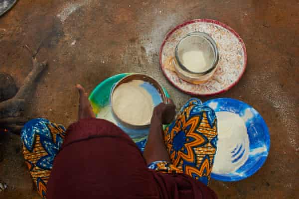 A woman seen from above sifting grain