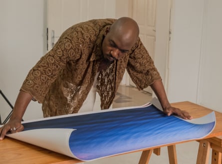 Nuits Balnéaires leans over a blue print opened out on a table