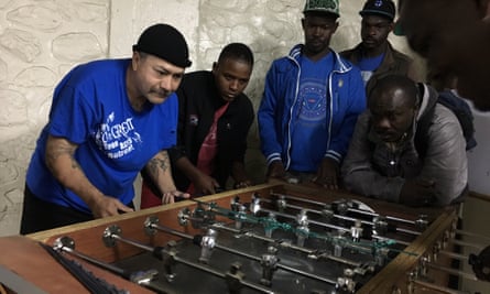 A deported Mexican migrant plays table football with Haitians at a Tijuana shelter.