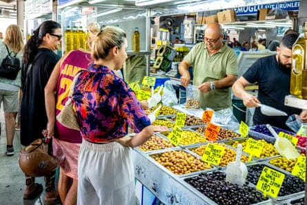 People buying olives in a market