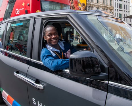 Bahrain Mujagata smiles as he sits behind the wheel of his black cab