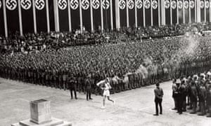The Olympic torch is carried into the stadium in Berlin on 1 August 1936.