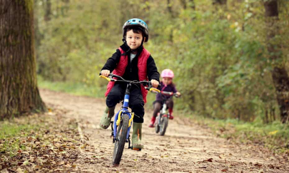 Boy and girl cycling in the woods.