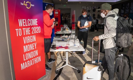 Eliud Kipchoge (right) registers at the official hotel and enters the biosecure bubble for the London Marathon on Sunday.