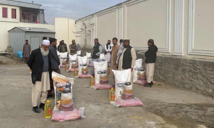 Mehrajuddin (left) at a Kabul food distribution centre collecting supplies for his family.