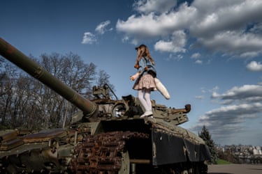 Marylise Vigneau, Kyiv, Ukraine, April 2025. A girl stands on a tank on a sunlit day.