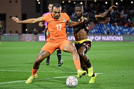 Ivory Coast's Guela Doue fights for the ball with Cameroon's Darlin Yongwa.