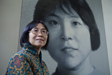 Former Red Guard Yu Xiangzhen poses in front of her picture by artist Xu Weixin.