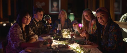 Cinq femmes assises autour d'une table à dîner fixent la caméra avec des expressions de désapprobation ou de moquerie