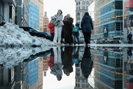 Gente paleando nieve en una calle de la ciudad