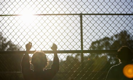 two young boys at a chain-link fence