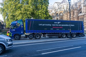 A large truck parked outside the Houses of Parliament promoting National Lorry Week. It is part of a Road Haulage Association campaign to get more people to sign up as HGV drivers.