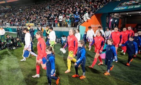 The Norway and Japan players exit the tunnel and walk onto the pitch alongside mascots.