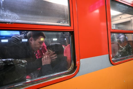 A man says goodbye to a woman who fled the war in Ukraine as they wait for the departure of a humanitarian train to relocate refugees to Berlin.