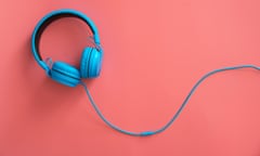 Bright blue headphones and lead seen on a pink background