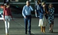 President Joe Biden talks on the phone as he walks to board Air Force One with members of his family. 