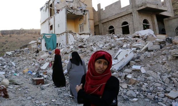Women walk through the debris of a housing block allegedly destroyed by Saudi-led airstrikes in Sana’a, the capital of Yemen