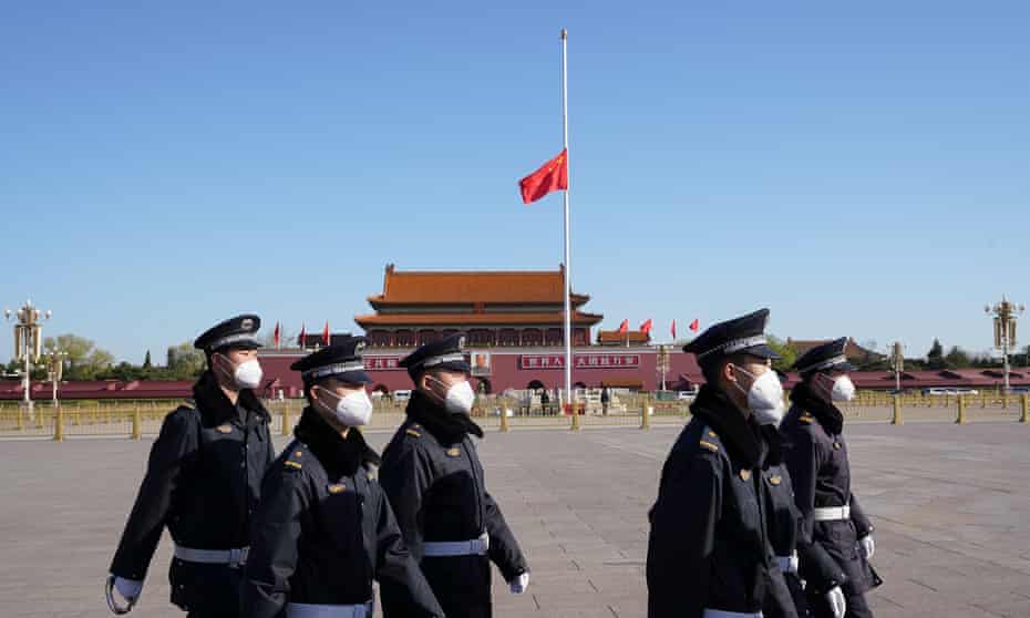 Chinese police march through Tiananmen Square before a national mourning for the victims of Covid-19