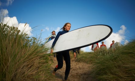 Group of surfers heading in dunes