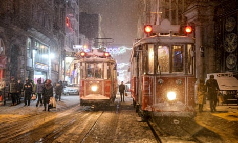 People walk through a snowfall in Istanbul. 
