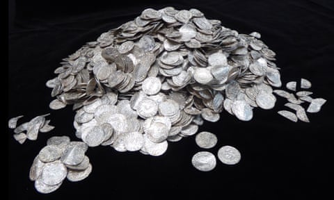 a mound of silver pennies against a black background