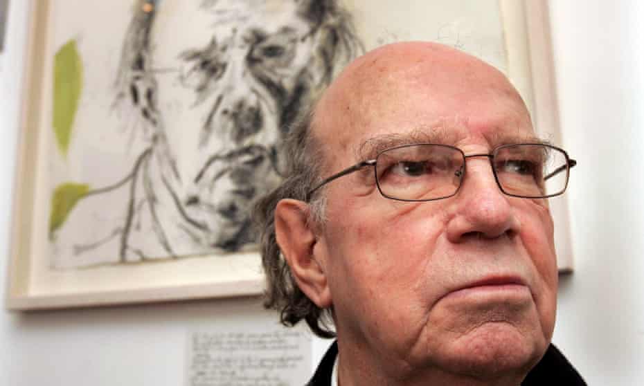 Anthony Cronin at the Royal Hibernian Academy, Dublin, in 2005, standing in front of a portrait of himself by Brian Maguire.