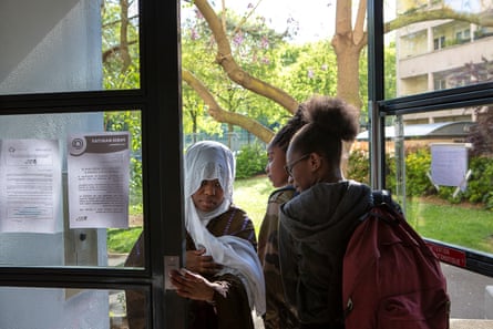 Assa Doucouré croise de jeunes étudiants à l'entrée de l'immeuble où habite sa mère, dans le 13e arrondissement de Paris, 2017