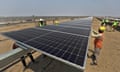 Workers installing solar panels in India