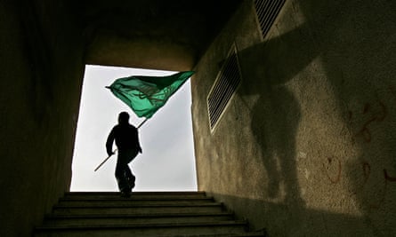 A Hamas supporter holds a green Islamic flag during an election campaign rally supporting the militant group on the outskirts of Jerusalem in 2006.
