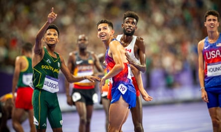 South Africa’s Adriaan Wildschutt points to scoreboard to show the result to bronze medallist Grant Fisher of the United States during the men’s 10000m final.