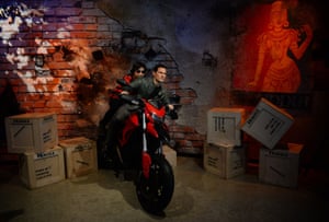 A visitor sits on a bike with Tom Cruise