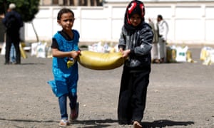 Yemeni children carrying food aid