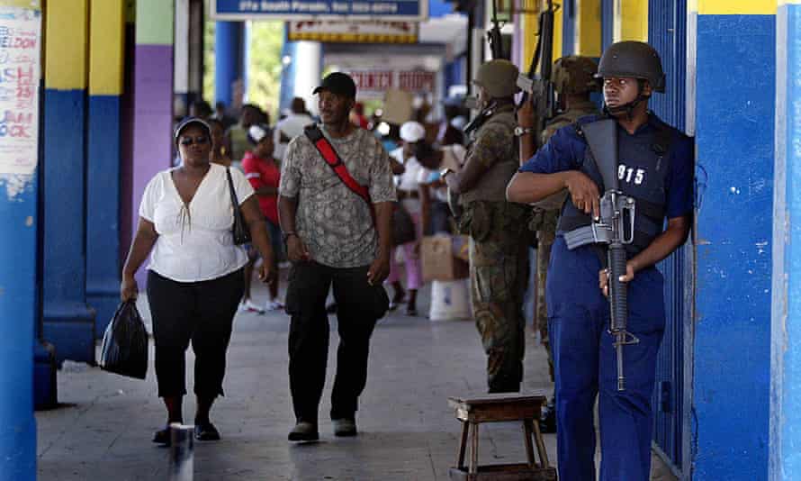 Armed police stand guard at a shopping centre in Kingston, Jamaica