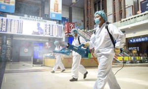 A photo released by China’s Xinhua News Agency showing workers spraying disinfectant in the central hall of the Beijing railway station.