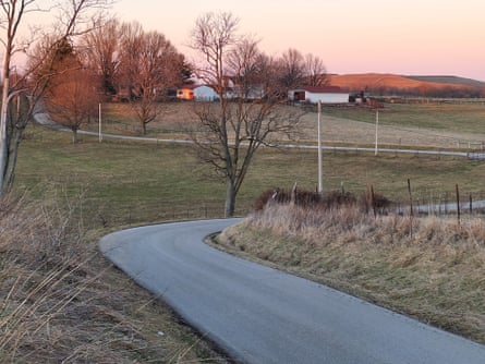 Farm buildings and trimmed grasslands at twilight.