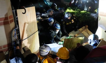 Police break through a barrier set up by protesters